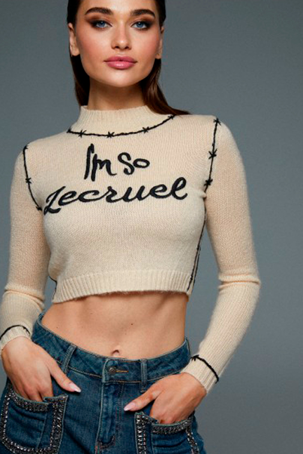 Jersey beige de Le Cruel con la frase "I'm so Lecruel" y detalles bordados.